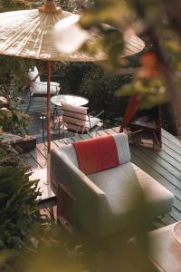 a couch with a red blanket sitting on a patio at Boutique Beach Retreat in Westward Ho