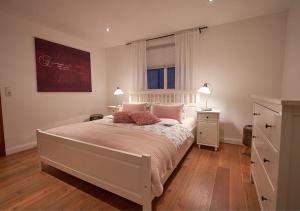 a bedroom with a bed with pink pillows and a window at Alte Schüre in Elpe