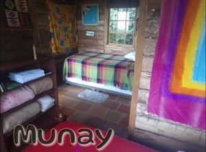 um quarto com uma cama num chalé de madeira em MUNAY, Posada rural para el sosiego em Alcalá
