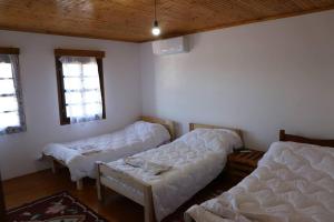 een kamer met 2 bedden en 2 ramen bij Villa Maria - Berat Castle in Berat