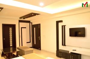 ein Wohnzimmer mit einem TV an der Wand in der Unterkunft Hotel MY Dream in Aligarh
