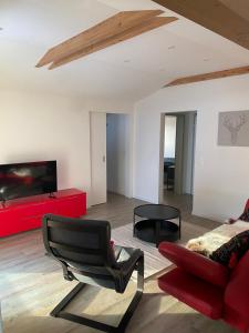 uma sala de estar com um sofá vermelho e uma cadeira em DG Russi Bella Vista em Andermatt