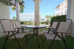 內爾哈的住宿－Sunstay PRIMERA LINEA DE PLAYA! Aptos Rio Marina，庭院里摆放着一组椅子和一张桌子
