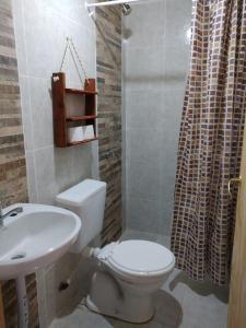 uma casa de banho com um WC branco e um lavatório. em Hospedaje Puntos Cardinales em Purmamarca