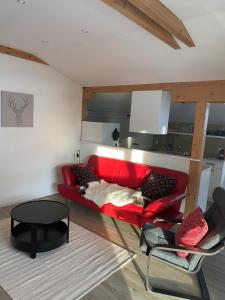 uma sala de estar com um sofá vermelho e uma mesa em DG Russi Bella Vista em Andermatt