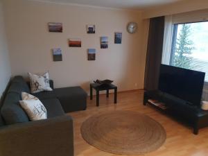 a living room with a couch and a flat screen tv at Make yourself at home in Rovaniemi
