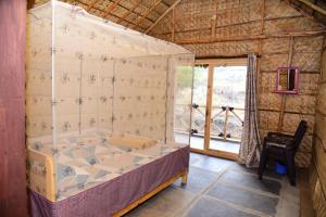 a canopy bed in a room with a window at Sunny Guest House Hampi in Hampi