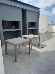 dos bancos sentados en la parte superior de un edificio en DPTO UN DORMITORIO C/COCHERA- CENTRO VILLA MARIA, en Villa María