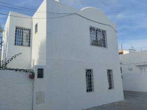 a white building with windows on the side of it at Duplex Hammamet in Hammamet