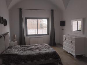 um quarto com uma cama, uma cómoda e uma janela em Duplex Hammamet em Hammamet