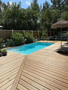 a swimming pool on a wooden deck next to a fence at Chez Karine & Eric in Le Teich