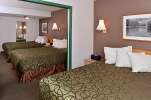 Habitación de hotel con 2 camas y espejo en Canadas Best Value Inn Valemount, en Valemount