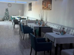 a dining room with tables and chairs and a christmas tree at Vila La Mer in Eforie Nord