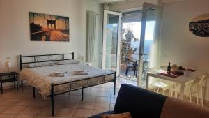 San Fermo della Battaglia的住宿－VILLA BELVEDERE_studio flat，一间卧室配有一张床铺和一张桌子,并设有一个阳台