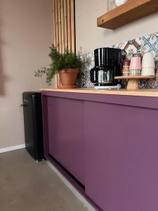 un mostrador púrpura en una cocina con un armario púrpura en B&B De Terpen, en Dokkum