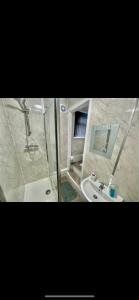 two pictures of a bathroom with a shower and a sink at Empire House in Burnley