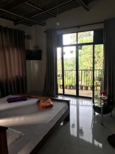 um quarto com uma cama e uma grande janela em Sky home stay em Kandy