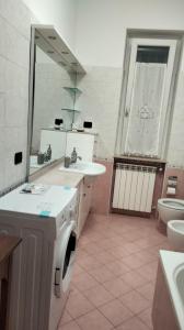 ein Badezimmer mit einem Waschbecken, einem WC und einem Spiegel in der Unterkunft Le Chic 2 Vanzago in Vanzago