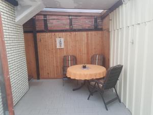 una mesa de madera y sillas en un patio en Gasthaus Katrin en Königslutter am Elm