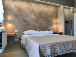 a bedroom with a large bed and a wall at Il Limoneto di Leo in Mascali