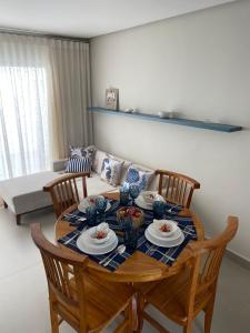 a dining room table with four chairs and a couch at Apt. Ah-Mar in Porto Seguro