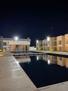 a swimming pool in front of a building at night at Apt. Ah-Mar in Porto Seguro