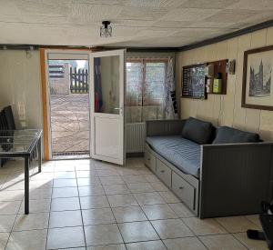 a living room with a couch and an open door at LE CEDRE BLEU in Saint-Michel-sur-Meurthe