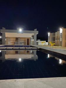a house with a swimming pool at night at Apt. Ah-Mar in Porto Seguro