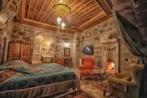 a bedroom with a bed and a fireplace at Traveller's Cave Hotel in Goreme