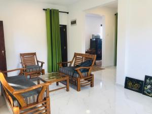 uma sala de estar com três cadeiras e uma mesa em Star Beach Villa em Tangalle