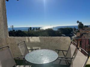 una mesa y sillas en un balcón con vistas al océano en Sunstay PRIMERA LINEA DE PLAYA! Aptos Rio Marina en Nerja