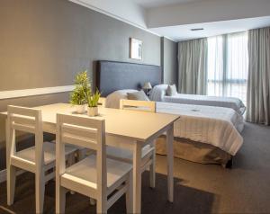 um quarto de hotel com uma mesa e uma cama em Visit Hotel & Apart em San Luis