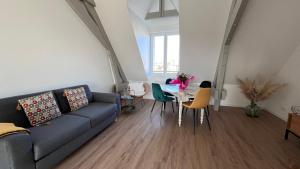 uma sala de estar com um sofá e uma mesa em L'Horizon de la Loire-Vue sur Blois et la Loire-6 pers em Blois