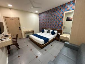 a bedroom with a bed with a blue patterned wall at HOTEL ATITHI INN in Vadodara