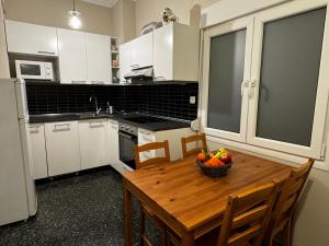 a kitchen with a wooden table with a bowl of fruit on it at Promenade city apartment in Thessaloniki