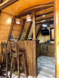 um bar numa cabana com dois bancos em Liki Home em Lerik