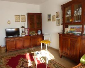 a living room with a tv and wooden furniture at La casa di Silvia in Massarosa