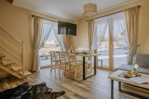 a kitchen and living room with a table and chairs at Domki ,,Dolina Dunajca,, in Frydman