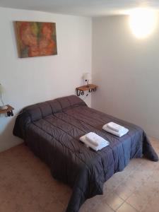 a bedroom with a bed with two towels on it at Meraki Classic in Villa Carlos Paz