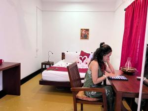 - une fille assise à une table dans une pièce avec un lit dans l'établissement Ananda Marari Heritage Villa, à Alappuzha 36 autres photos