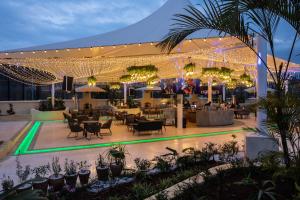 un patio al aire libre con mesas, sillas y luces en Argyle Grand Hotel Nairobi Airport, en Nairobi