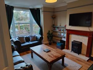 a living room with a couch and a fireplace at The Halt, Sheringham - 2x car spaces, Family friendly holiday home close to beach in Sheringham