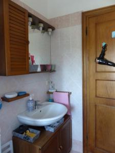 a bathroom with a sink and a wooden door at La casa di Silvia in Massarosa