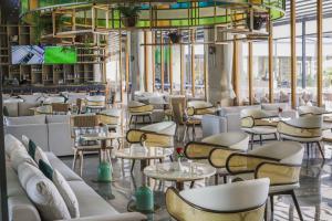 a restaurant with white chairs and tables at Argyle Grand Hotel Nairobi Airport in Nairobi