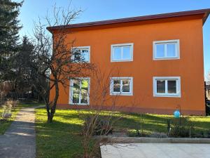 una casa naranja con ventanas blancas en un patio en city apartment, en Graz