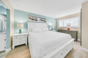a bedroom with a white bed and two night stands at The Summit 1426 in Panama City Beach +36 photos