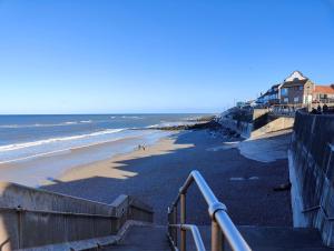 a beach with stairs leading down to the ocean at The Halt, Sheringham - 2x car spaces, Family friendly holiday home close to beach in Sheringham