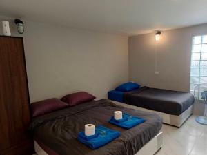 um quarto com duas camas com bandejas azuis em MediLeaf Hostel em Haad Rin