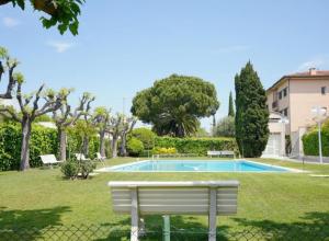 a white bench in a park with a swimming pool at Apartamento Duplex Voramar in S'agaro