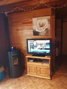 a television sitting on a stand in a room at Chalet 94 la boverie in Rendeux
